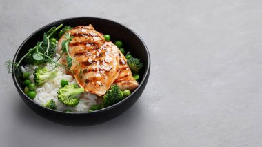 Yeşil sebzeli ızgara tavuk ve gri arka planda pirinç. Sağlıklı beslenme konsepti. Boşluğu kopyala