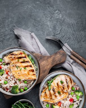 Sebzeli ızgara tavuk ve gri arka planda pilav. Sağlıklı beslenme konsepti. Üst görünüm, düz görünüm, kopyalama alanı