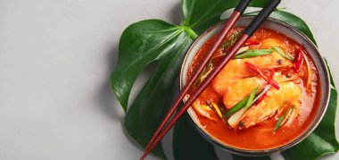 Açık gri arka planda tavuklu kırmızı köri. Geleneksel Asya yemekleri. Üst görünüm, düz görünüm, kopyalama alanı