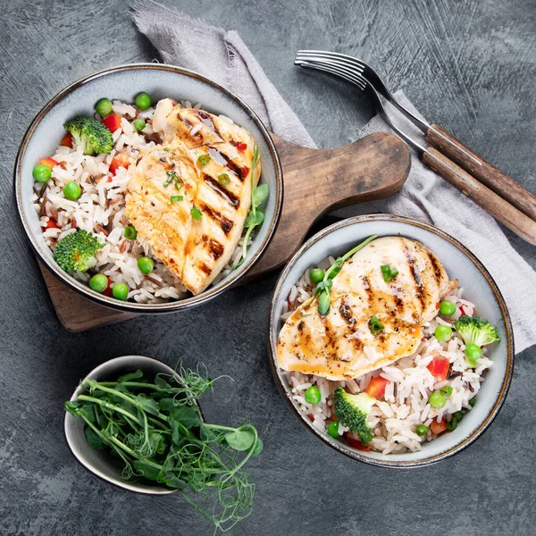 Sebzeli ızgara tavuk ve gri arka planda pilav. Sağlıklı beslenme konsepti. Üst manzara, düz uzanma