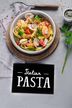 Gri arka planda deniz mahsullü makarna. Geleneksel İtalyan yemeği konsepti. Üst görünüm, düz görünüm, kopyalama alanı