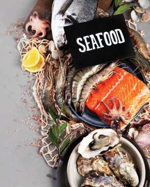 Açık gri arka planda balık çeşitleri. Akdeniz yemekleri konsepti. Düz konum, üst görünüm, kopyalama alanı