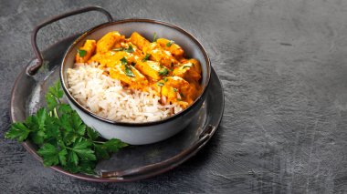 Hint tereyağlı körili tavuk ve koyu arkaplanda basmati pilavı. Geleneksel ev yapımı yemek konsepti. Boşluğu kopyala
