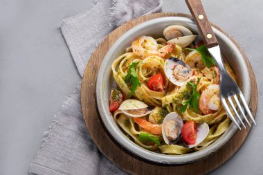 Gri arka planda deniz mahsullü makarna. Geleneksel İtalyan yemeği konsepti. Üst görünüm, düz görünüm, kopyalama alanı