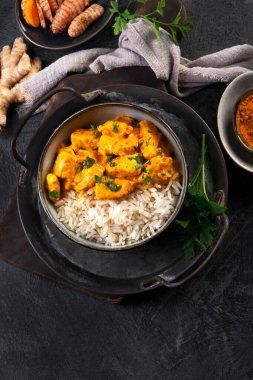 Hint tereyağlı körili tavuk ve koyu arkaplanda basmati pilavı. Geleneksel ev yapımı yemek konsepti. Üst görünüm, alanı kopyala