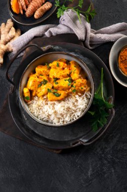 Hint tereyağlı körili tavuk ve koyu arkaplanda basmati pilavı. Geleneksel ev yapımı yemek konsepti. Üst görünüm, alanı kopyala