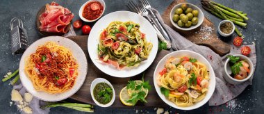 Esmer arka planda makarna çeşitleri. Geleneksel İtalyan yemeği konsepti. Üst manzara, düz uzanma