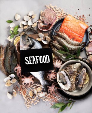 Açık gri arka planda balık çeşitleri. Akdeniz yemekleri konsepti. Düz konum, üst görünüm, kopyalama alanı