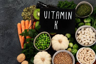 Koyu arka planda yüksek K vitamini içeren yiyecekler. Sağlıklı beslenme konsepti. Üst görünüm, düz görünüm, kopyalama alanı