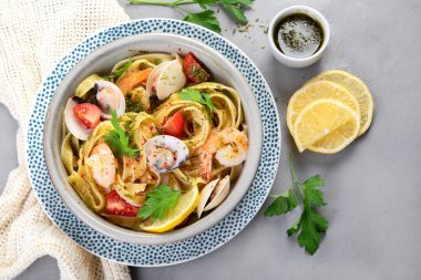 Gri arka planda deniz mahsullü makarna. Geleneksel İtalyan yemeği konsepti. Üst görünüm, düz görünüm, kopyalama alanı