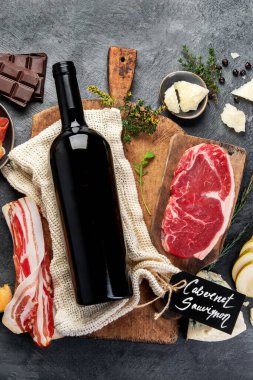 Gri arka planda Cabernet Sauvignon. Geleneksel alkol içecekleri. Kırmızı şarap çeşidi. Üst görünüm, düz görünüm, kopyalama alanı