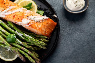 Gri arka planda kuşkonmaz ile pişirilmiş somon balığı. Akdeniz diyeti konsepti. Düz konum, üst görünüm, kopyalama alanı