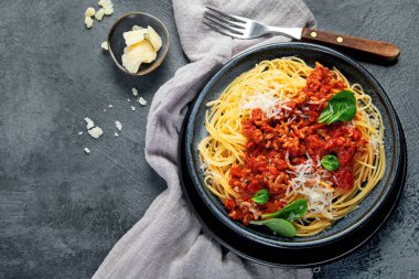 Gri arka planda spagetti bolonez. Geleneksel İtalyan makarnası. Ev yapımı yemek konsepti. Üst görünüm, düz görünüm, kopyalama alanı