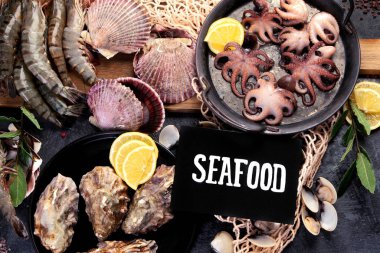 Karanlık arka planda taze deniz ürünleri düzenlemesi. Akdeniz diyeti konsepti. Düz yatış, üst görünüm