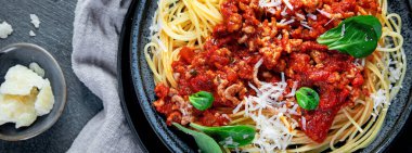 Gri arka planda spagetti bolonez. Geleneksel İtalyan makarnası. Ev yapımı yemek konsepti. Üst manzara, düz uzanma