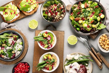 Gri arka planda vejetaryen yemekleri. Sağlıklı gıda konsepti. Üst manzara, düz uzanma