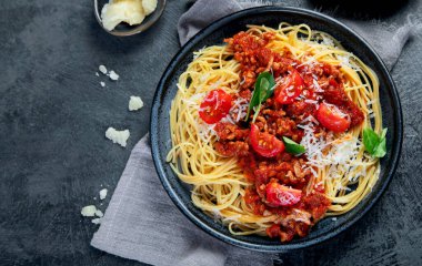 Gri arka planda spagetti bolonez. Geleneksel İtalyan makarnası. Ev yapımı yemek konsepti. Üst görünüm, düz görünüm, kopyalama alanı