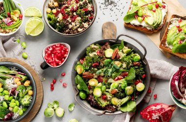 Gri arka planda vejetaryen yemekleri. Sağlıklı gıda konsepti. Üst manzara, düz uzanma