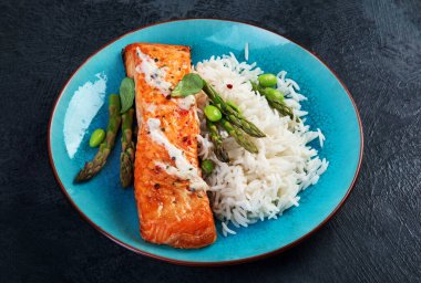 Gri arka planda pilav ve kuşkonmaz ile pişirilmiş somon. Akdeniz diyet kavramı. 