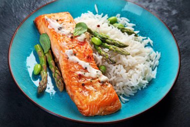 Gri arka planda pilav ve kuşkonmaz ile pişirilmiş somon. Akdeniz diyet kavramı.