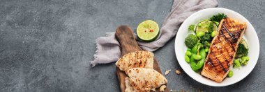 Koyu arkaplanda sebzeli haşlanmış somon balığı. Akdeniz diyeti konsepti. Düz konum, üst görünüm, kopyalama alanı, panorama