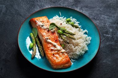 Gri arka planda pilav ve kuşkonmaz ile pişirilmiş somon. Akdeniz diyet kavramı.