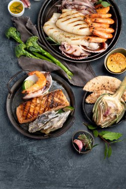 Koyu arka planda ızgara balık ve deniz ürünleri çeşitleri. Ev yapımı yemek konsepti. Üst görünüm, düz görünüm, kopyalama alanı