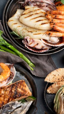 Koyu arka planda ızgara balık ve deniz ürünleri çeşitleri. Ev yapımı yemek konsepti. Üst görünüm, düz görünüm, kopyalama alanı