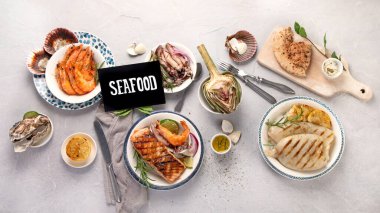 Hafif arka planda ızgara balık ve deniz ürünleri çeşitleri. Ev yapımı yemek konsepti. Üst manzara, düz uzanma