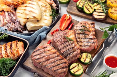 Izgara balık, deniz ürünleri ve arka planda et çeşitleri. Ev yapımı gıda konsepti. 