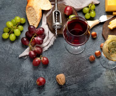 Gri arka planda aperatifleri olan kırmızı şarap. Parti için yaz içeceği, şarap dükkanı ya da şarap tatma konsepti. Düz konum, üst görünüm, kopyalama alanı