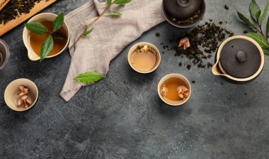 Koyu arkaplanda Asya çayı seti. Bitki yaprakları, doğal bitki çayı kompozisyonu. Üst görünüm, düz görünüm, kopyalama alanı