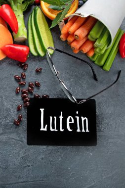 Lutein içerikli ve karanlık arka planda yiyecekler. Sağlıklı gözler için yiyecek. Yüksek miktarda antioksidan, mineral ve vitamin. Üst görünüm, düz görünüm, kopyalama alanı
