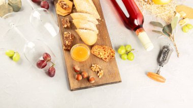 Gri arka planda atıştırmalıklar olan bir şişe gül şarabı. Parti için yaz içeceği, şarap dükkanı ya da şarap tatma konsepti. Boşluğu kopyala