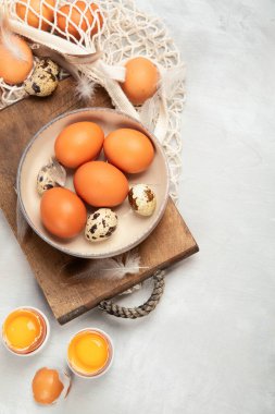 Gri arka planda tavuk yumurtası kompozisyonu. Çiftlik ürünleri ve doğal beslenme. Üst görünüm, düz görünüm, kopyalama alanı