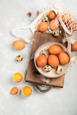 Gri arka planda tavuk yumurtası kompozisyonu. Çiftlik ürünleri ve doğal beslenme. Üst görünüm, düz görünüm, kopyalama alanı