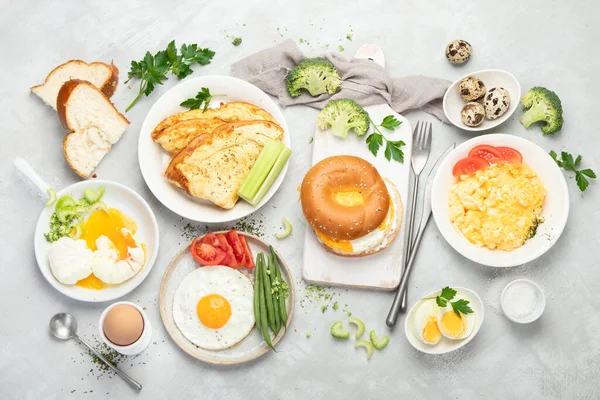 Various ways of cooking chicken eggs on light background. Breakfast food concept. Flat lay, top view