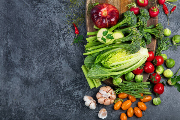 Вкусные сырые фрукты и овощи на темном фоне. Концепция здорового питания. Вид сверху, плоский, копировальное пространство