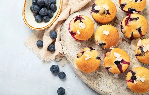 木の板の上にブルーベリーとマフィン 新鮮な果実と白い背景の甘いペストリー トップビュー — ストック写真