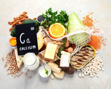 Hafif arka planda yüksek kalsiyum içeren sağlıklı yiyecekler. Süt ürünleri, sebzeler ve süper yiyecekler. Ca ürünleri. Üst manzara, düz uzanma