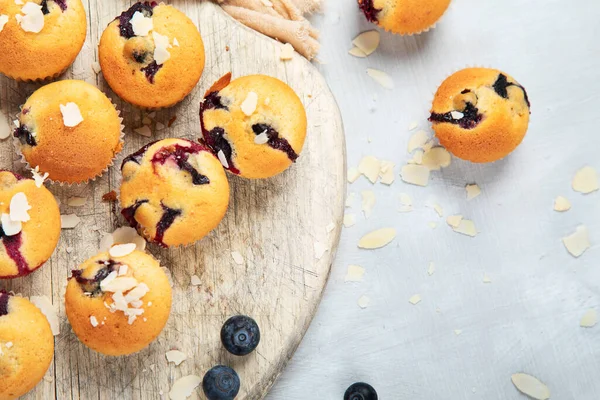 Tahta tabakta yaban mersinli kek. Beyaz arkaplanda taze böğürtlen ve tatlı hamur işleri, fotokopi alanı ile üst görünüm.