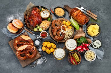 Karanlık arka planda Alman mutfağı. Geleneksel gıda konsepti. Izgara et ve abur cubur. Üst manzara, düz uzanma