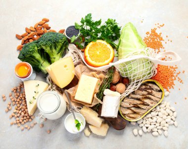 Hafif arka planda yüksek kalsiyum içeren sağlıklı yiyecekler. Süt ürünleri, sebzeler ve süper yiyecekler. Ca ürünleri. Üst manzara, düz uzanma