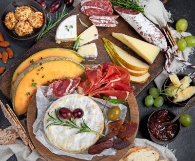 Koyu arka planda aperatifler. Akdeniz yemekleri konsepti. Peynir çeşitleri. Üst manzara, düz uzanma