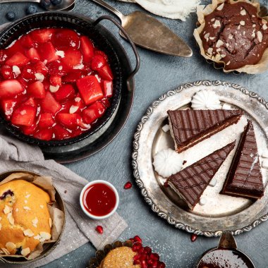 Pasta ve atıştırmalıklarla dolu bir tatlı masası. Çikolata. Kutlama konsepti. Üst manzara, düz uzanma
