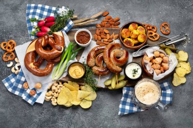 Ekim Festivali yemek masası konsepti ızgara domuz sosisi, kraker, patates, salata, aperatif, sos, koyu arkaplanda bira, üst görünüm..