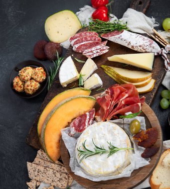 Koyu arka planda aperatifler. Akdeniz yemekleri konsepti. Peynir çeşitleri. Üst görünüm, düz görünüm, kopyalama alanı