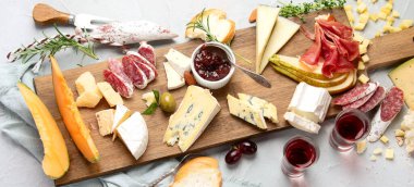 Hafif arka planda peynir çeşitleri. Gurme aperatifleri tepside. İtalyan yemeği konsepti. Üst manzara, düz yatış, manzara