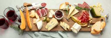 Hafif arka planda peynir çeşitleri. Gurme aperatifleri tepside. İtalyan yemeği konsepti. Üst manzara, düz yatış, manzara