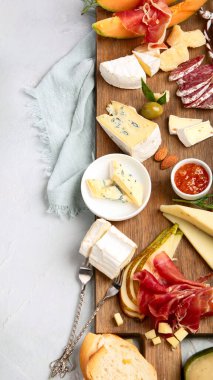 Hafif arka planda peynir çeşitleri. Gurme aperatifleri tepside. İtalyan yemeği konsepti. Üst görünüm, düz görünüm, kopyalama alanı